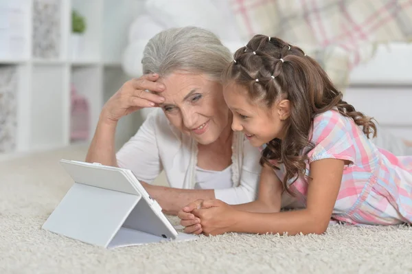 Menina com avó usando tablet — Fotografia de Stock