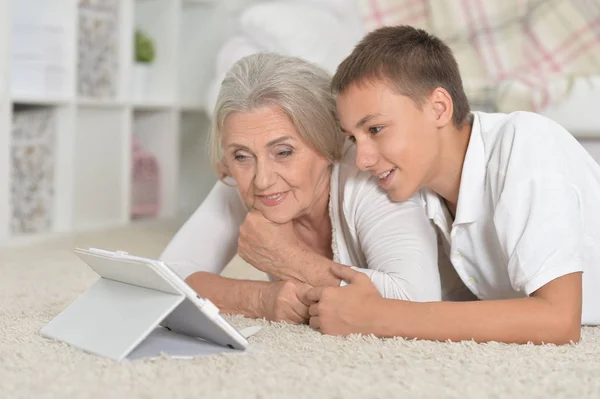 Девушка с бабушкой с помощью планшета — стоковое фото