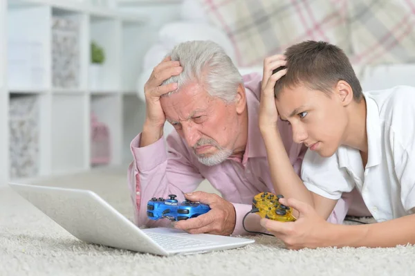 Farfar Och Barnbarn Liggande Golvet Och Spelar Dataspel Laptop — Stockfoto