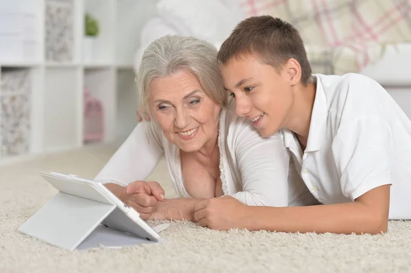 Dívka s babičkou pomocí tabletu — Stock fotografie