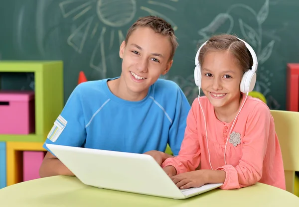 Hermano y hermana usando laptop — Foto de Stock
