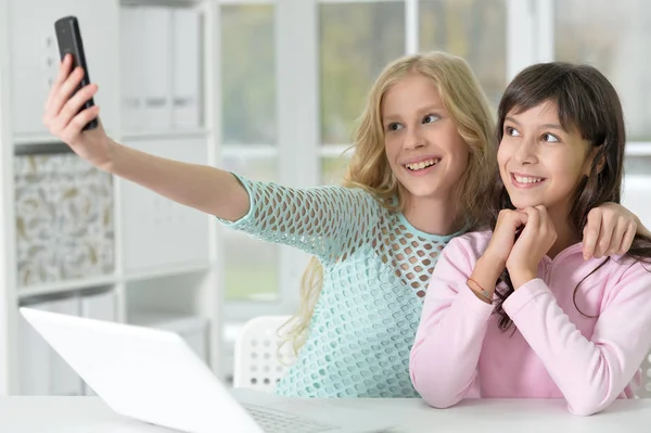 Duas meninas com telefone e laptop — Fotografia de Stock