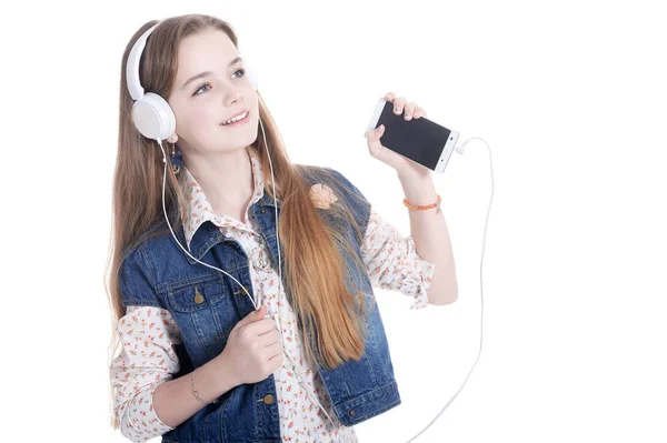 快乐的小女孩在牛仔裤夹克听音乐与智能手机在白色背景下隔离 — 图库照片