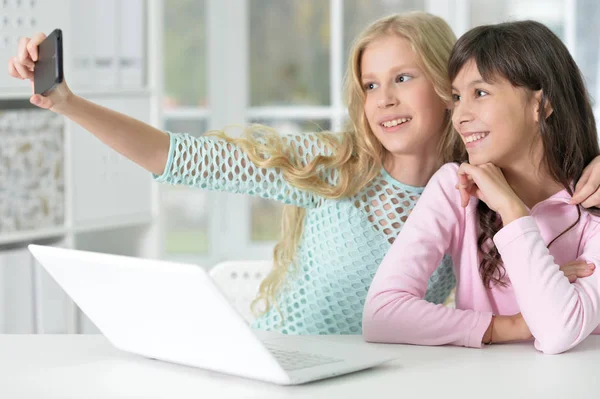 Två tjejer med telefon och laptop — Stockfoto