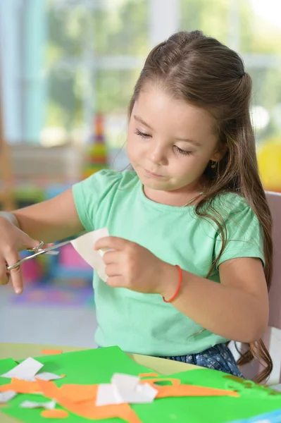 Llittle girl is cutting color paper — Stock Photo, Image