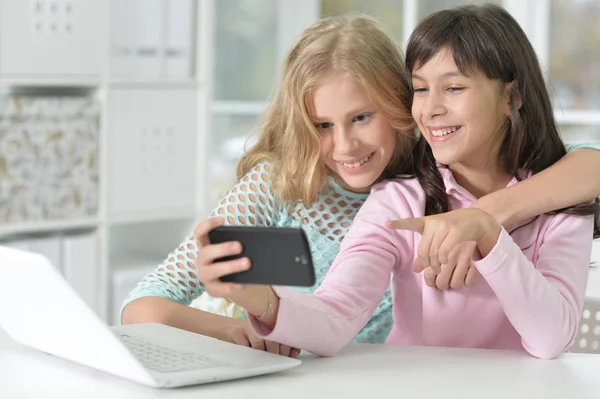 Duas meninas com telefone e laptop — Fotografia de Stock