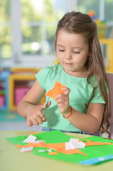 Llittle meisje is het snijden van papier van de kleur — Stockfoto