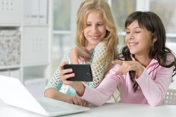 Two girls with phone and laptop — Stock Photo, Image