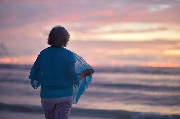 Elderly woman at sunset — Stock Photo, Image