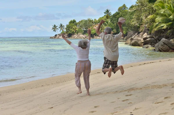 Casal de idosos descansam na praia tropical — Fotografia de Stock