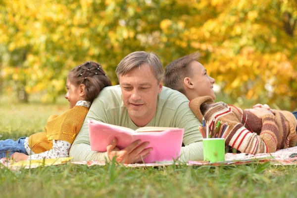 家庭和书一起在公园里休息 — 图库照片