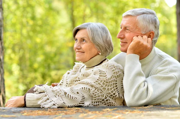 Elderly couple at table in forest — Stock Photo, Image