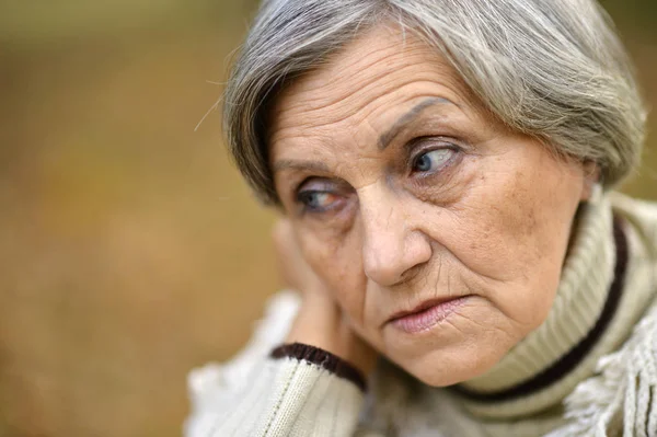 Oudere vrouw in de herfst — Stockfoto