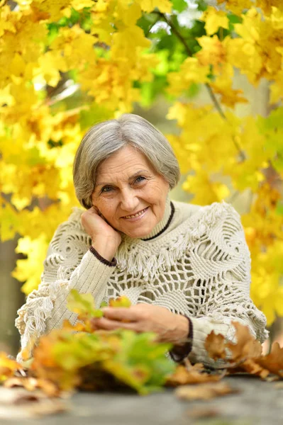 Oudere vrouw in de herfst — Stockfoto