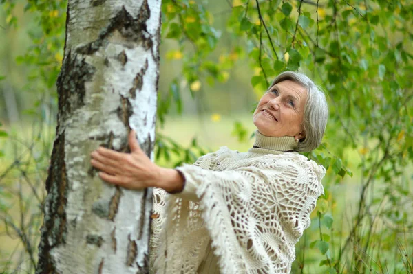 Mujer mayor junto al árbol — Foto de Stock