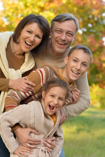 秋の公園で休んで幸せな若いご家族の肖像画 — ストック写真