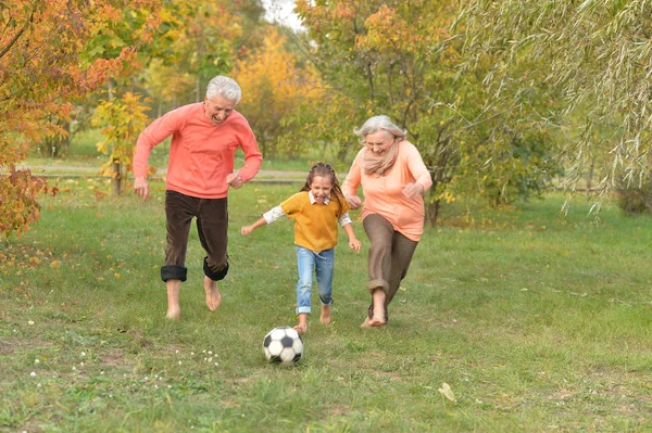 祖父母和孙女在公园踢足球 — 图库照片