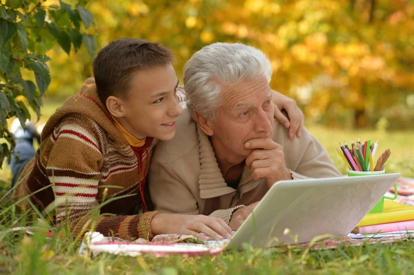 Pojke och farfar med laptop — Stockfoto