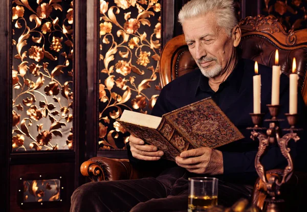 Homem Sênior Lendo Livro Enquanto Sentado Cadeira Vintage Casa — Fotografia de Stock