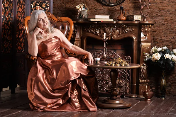 Mulher Sênior Bonita Vestido Dourado Cadeira Vintage — Fotografia de Stock