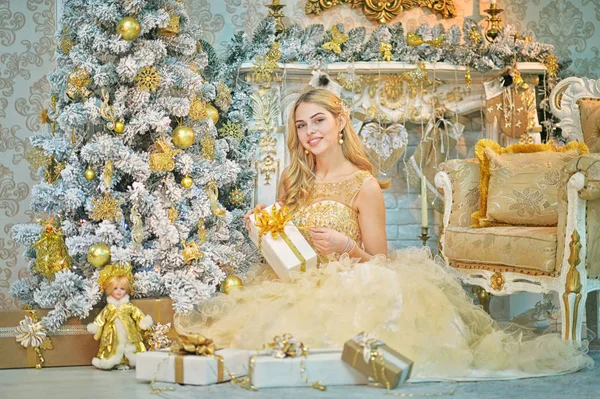 クリスマス休暇のため内装の部屋で贈り物と美しい若い女性 — ストック写真