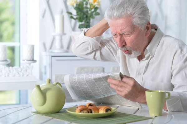 Känslomässiga Senior Man Läsa Tidningen Hemma — Stockfoto