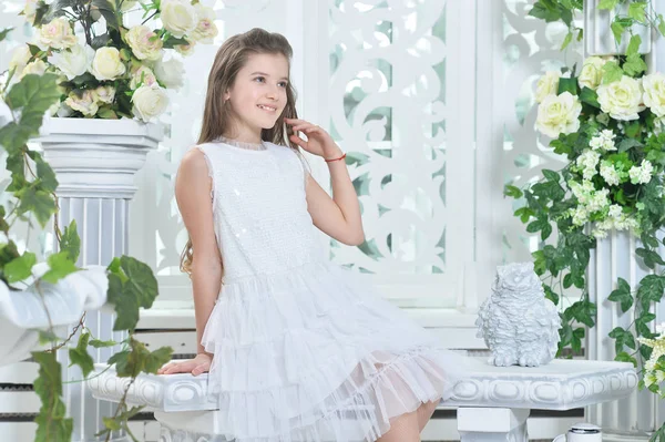 Счастливая Маленькая Девочка Белом Платье Позирует Комнате Украшены Цветами — стоковое фото