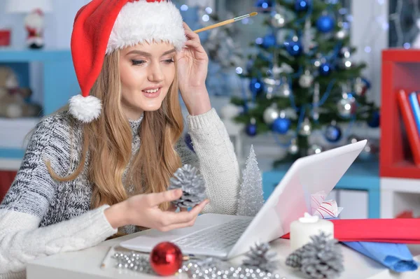 Frau mit Weihnachtsmütze mit Laptop — Stockfoto