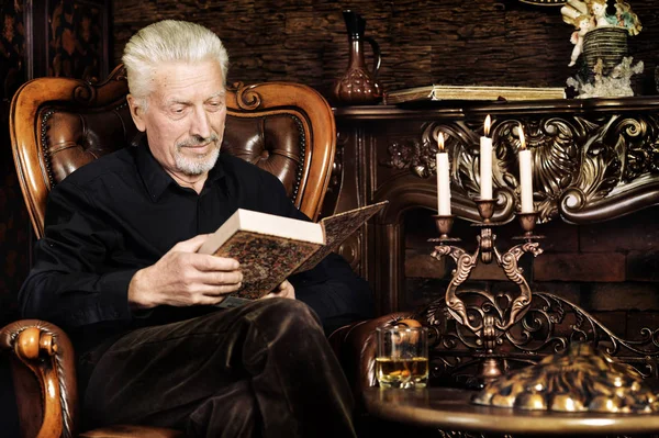 Hombre Mayor Leyendo Libro Mientras Está Sentado Silla Vintage Casa — Foto de Stock