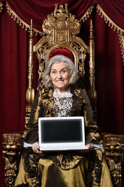 Senior woman sitting in vintage chair — Stock Photo, Image