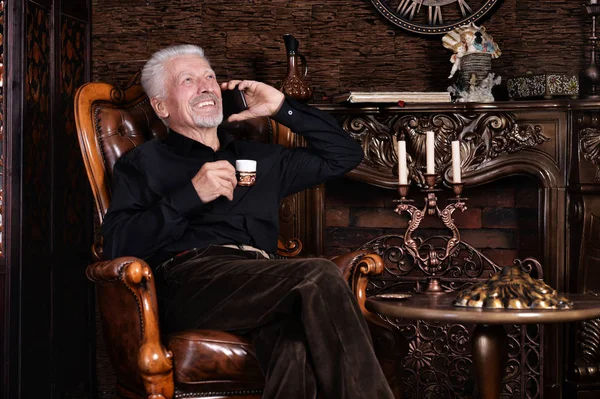 Uomo Anziano Sorridente Bere Caffè Parlare Telefono Mentre Seduto Sulla — Foto Stock