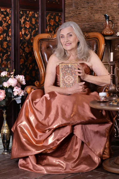 Hermosa Mujer Mayor Vestido Oro Con Libro — Foto de Stock