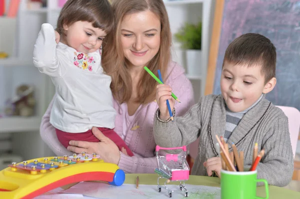 子供たちと一緒に家で遊んでいる母親 ストック画像