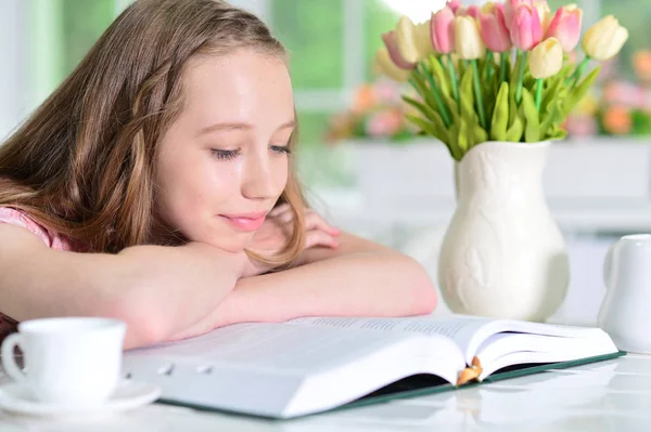 Söt Skolflicka Sitter Vid Bord Och Läsa Hemma — Stockfoto