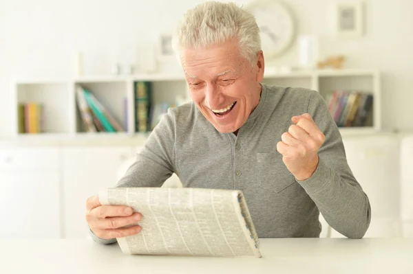 Emotional Senior Man Reading Newspaper Home — Stock Photo, Image
