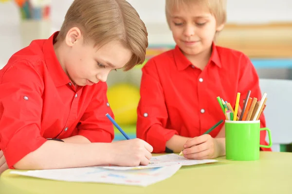 Två Leende Pojkar Röda Tröjor Ritning Med Pennor När Sitter — Stockfoto