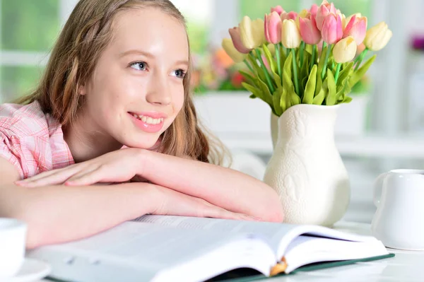 Söt Skolflicka Sitter Vid Bord Och Läsa Hemma — Stockfoto