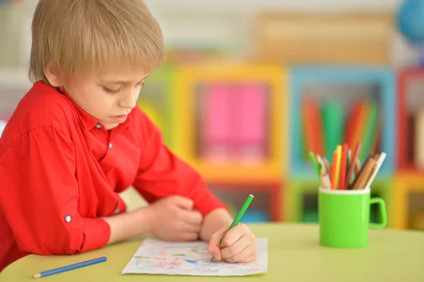 可爱的小男孩坐在桌旁用铅笔画画的肖像 — 图库照片