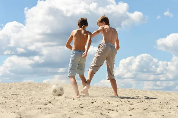 两个兄弟夏天在海滩踢足球 — 图库照片
