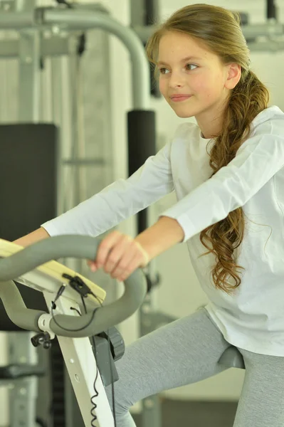 小女孩在健身房里骑自行车做运动 — 图库照片