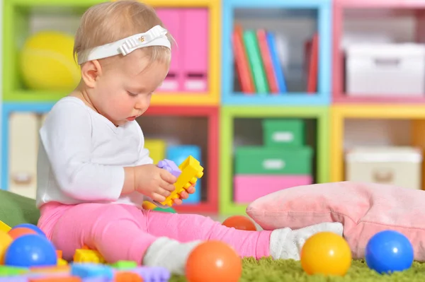 Маленький ребенок играет с красочными игрушками — стоковое фото