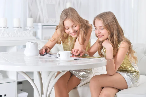 Retrato Hermanas Gemelas Lindas Sentadas Mesa Cocina Con Revista Moderna — Foto de Stock