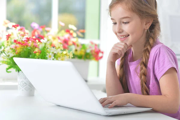 Маленькая девочка с современным ноутбуком — стоковое фото