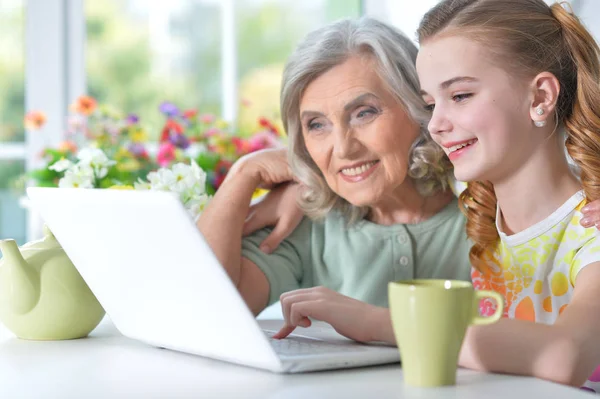 Girl with grandmother using laptop — Stock Photo, Image