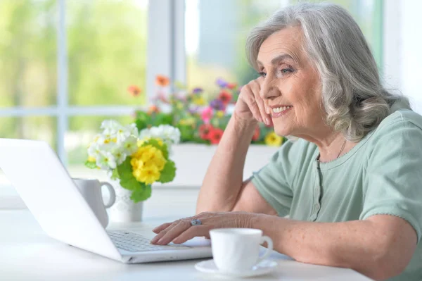 Bela Mulher Sênior Usando Laptop Enquanto Bebe Chá — Fotografia de Stock