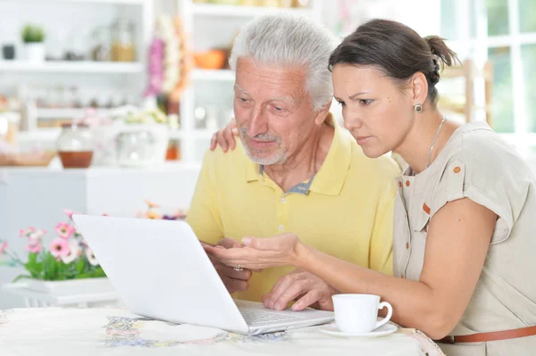 家でノート パソコンを使用して若い女性と年配の男性 — ストック写真