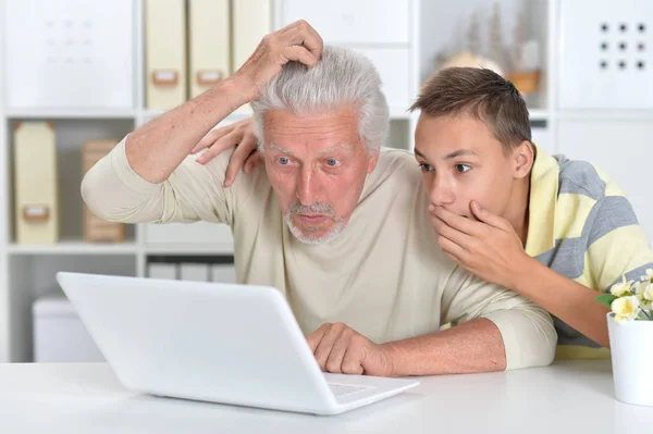 感情的な少年と自宅のノート パソコンで祖父の肖像画 — ストック写真