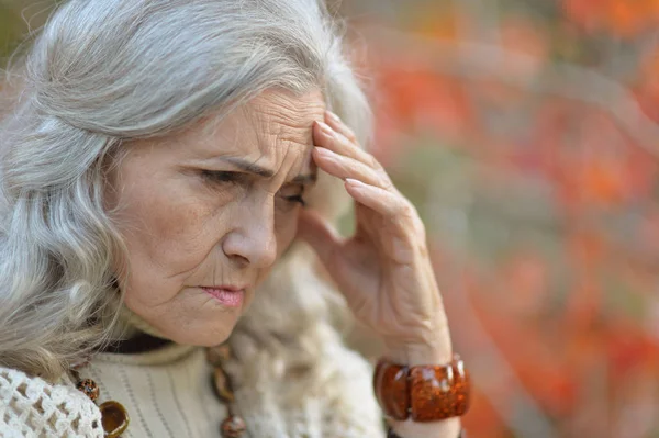 Triste Mujer Mayor Con Dolor Cabeza Parque Otoño —  Fotos de Stock