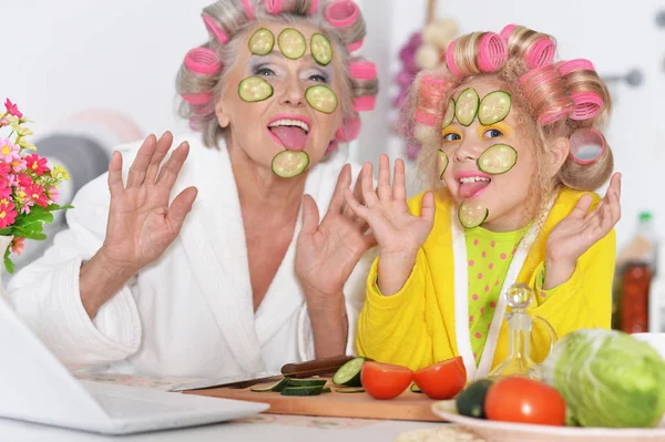 Senior woman and granddaughter at kitchen — Stock Photo, Image