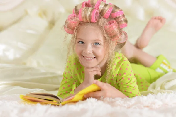 Preciosa Niña Con Rizadores Rosados Leyendo Cama Casa —  Fotos de Stock